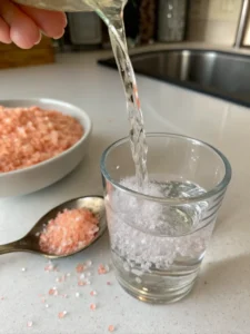 stirring pink Himalayan salt into warm water